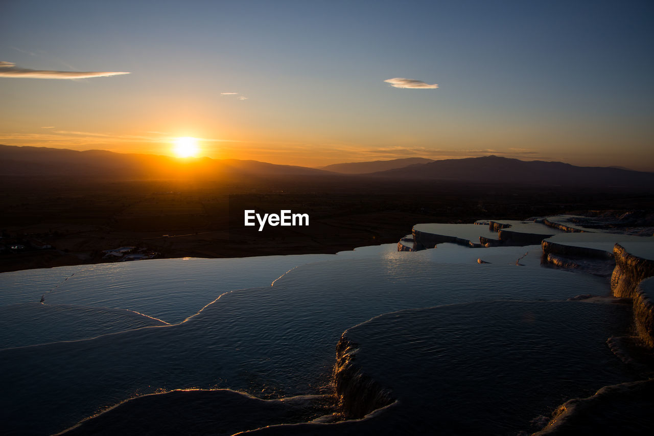 SCENIC VIEW OF SEA AGAINST ORANGE SKY