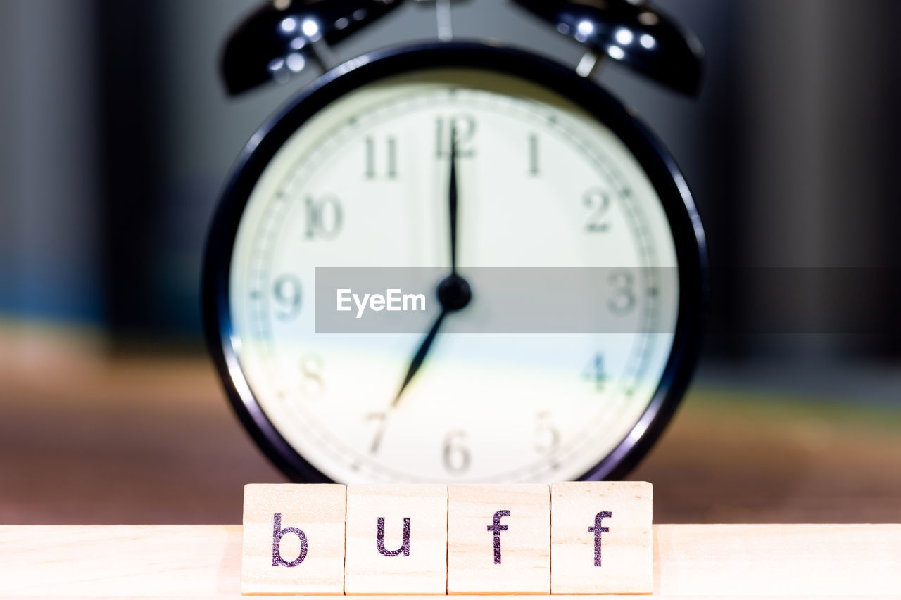 Close-up of alarm clock with text on table 