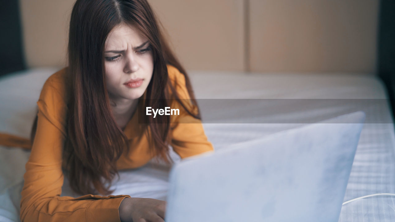 portrait of young woman using laptop at home