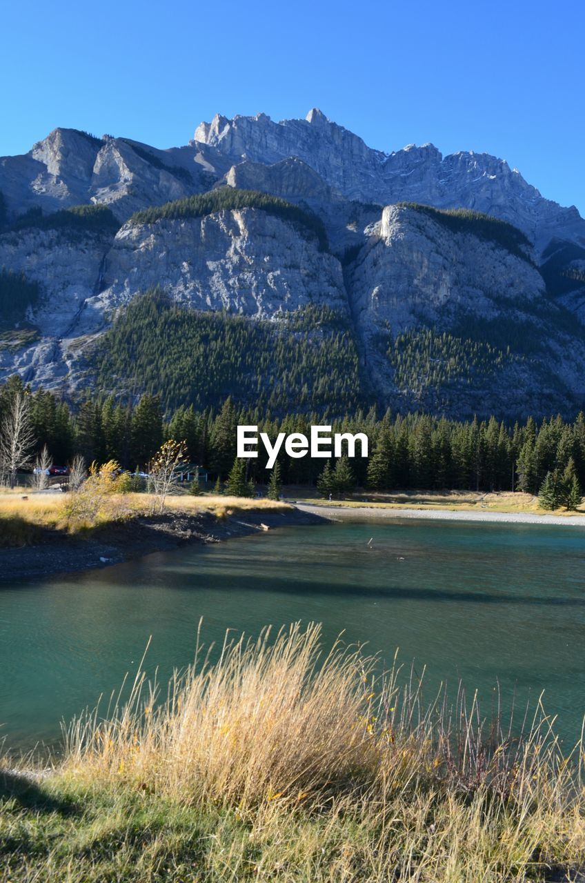 Scenic view of lake by mountains against sky