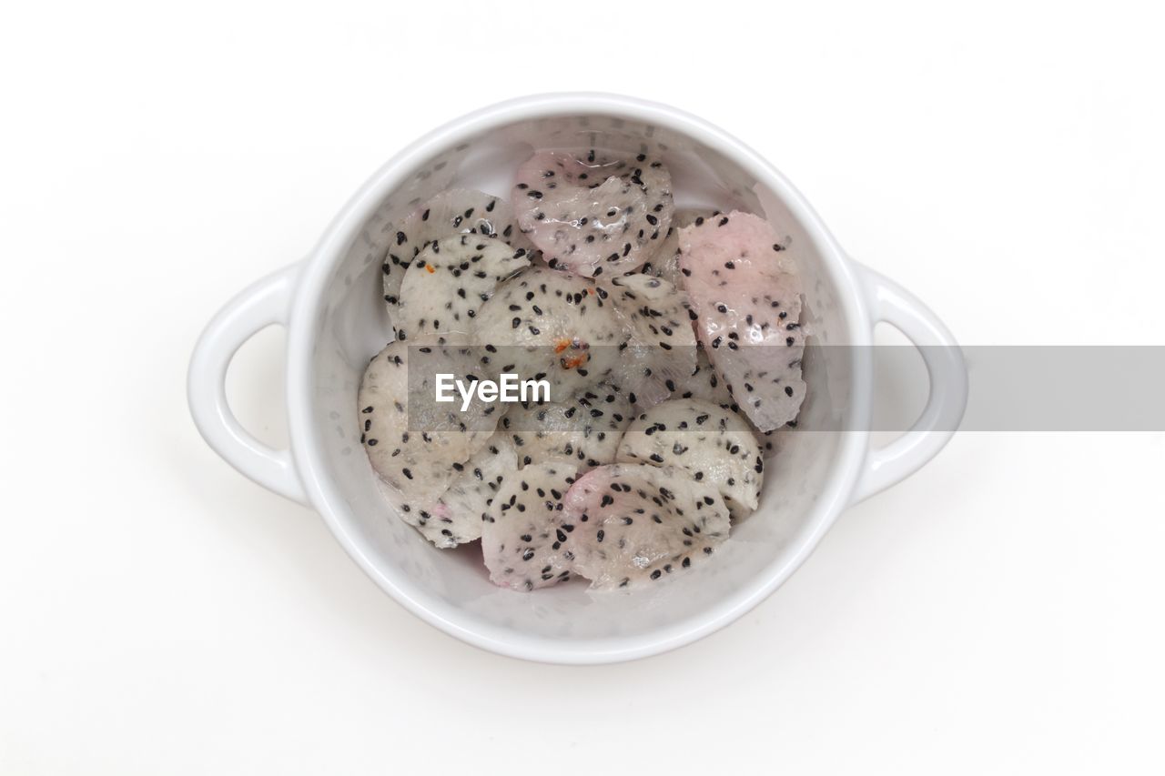 Directly above view of dragon fruit in bowl on white background