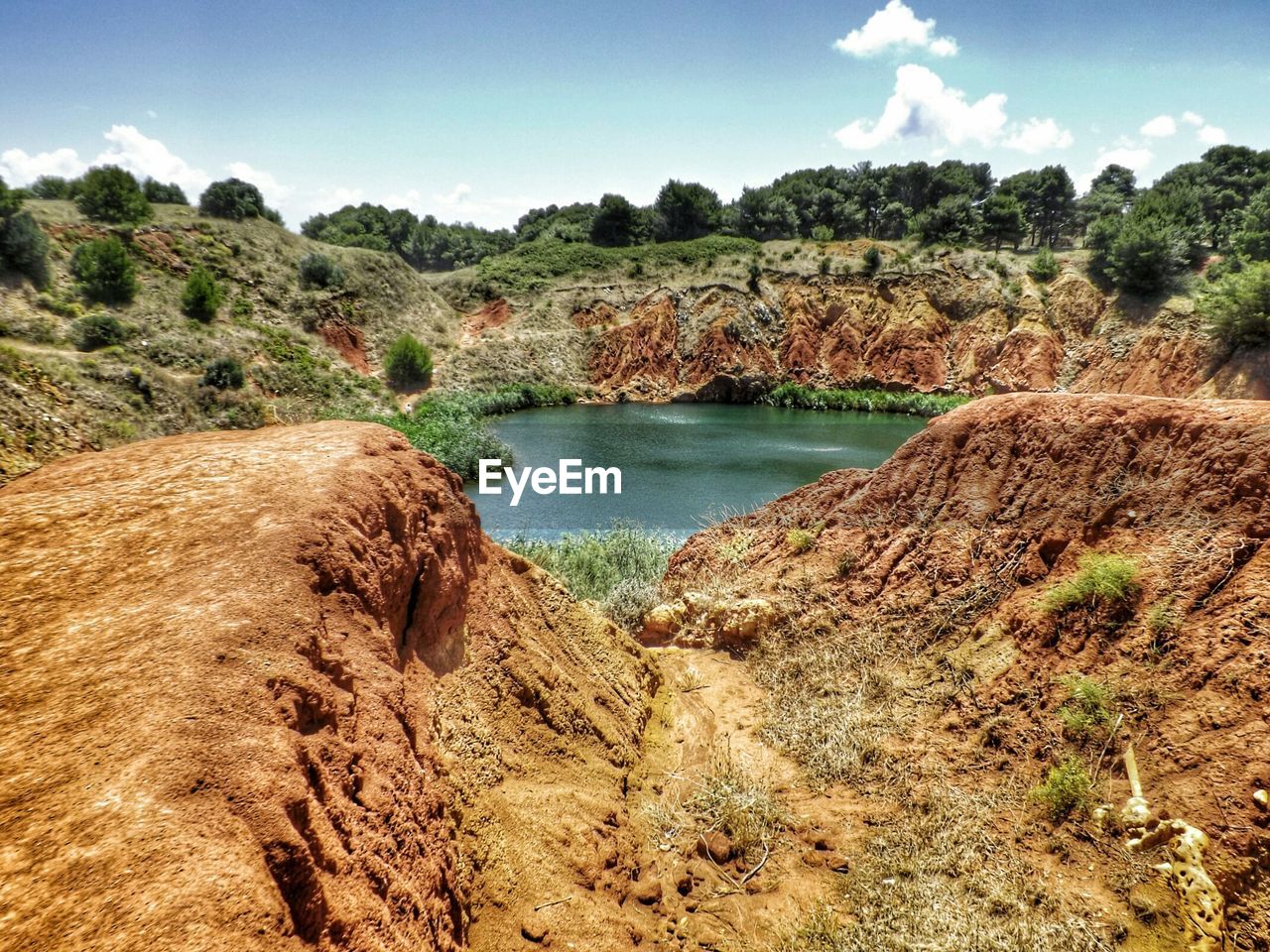 Pond amidst rocks against sky