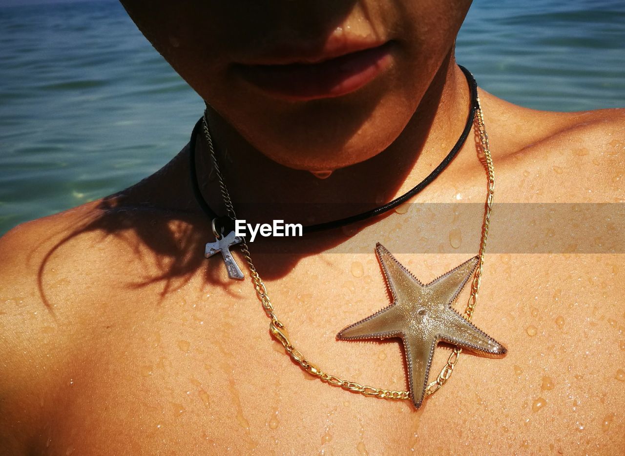 Midsection of boy with starfish on chest