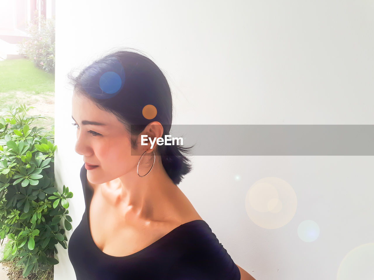 High angle view of beautiful woman looking away against wall