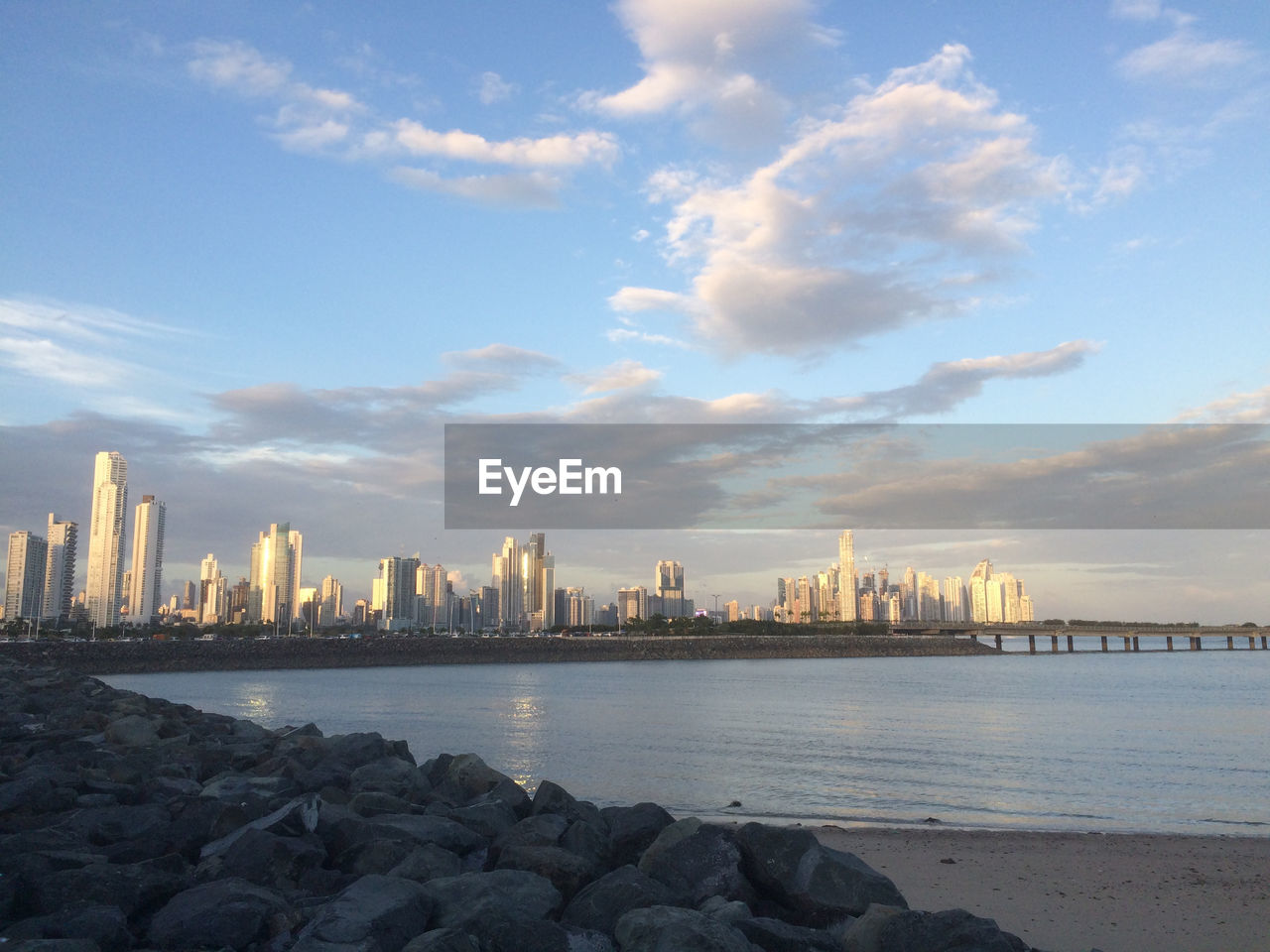 Sea by city buildings against sky