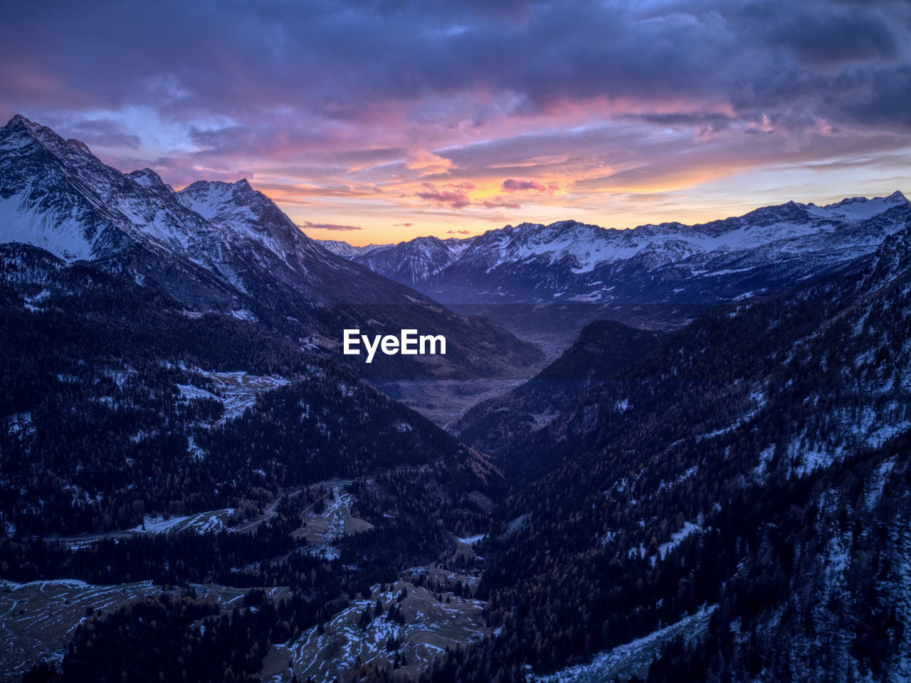 SCENIC VIEW OF SNOW MOUNTAINS AGAINST SKY DURING SUNSET