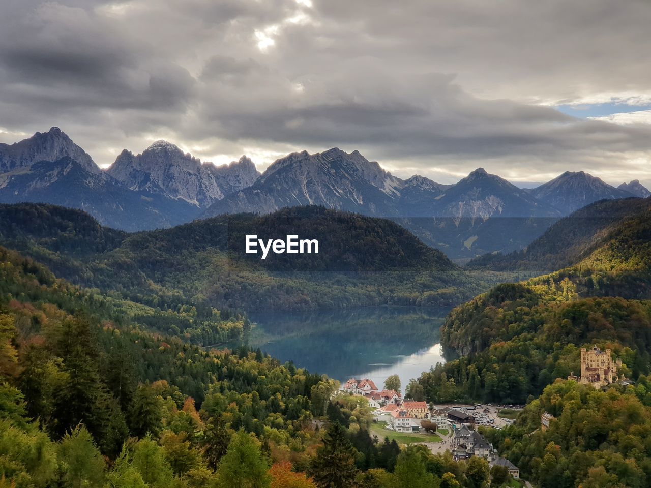 Scenic view of mountains, lake, forest and castle against grey sky - view from neuschwanstein castle