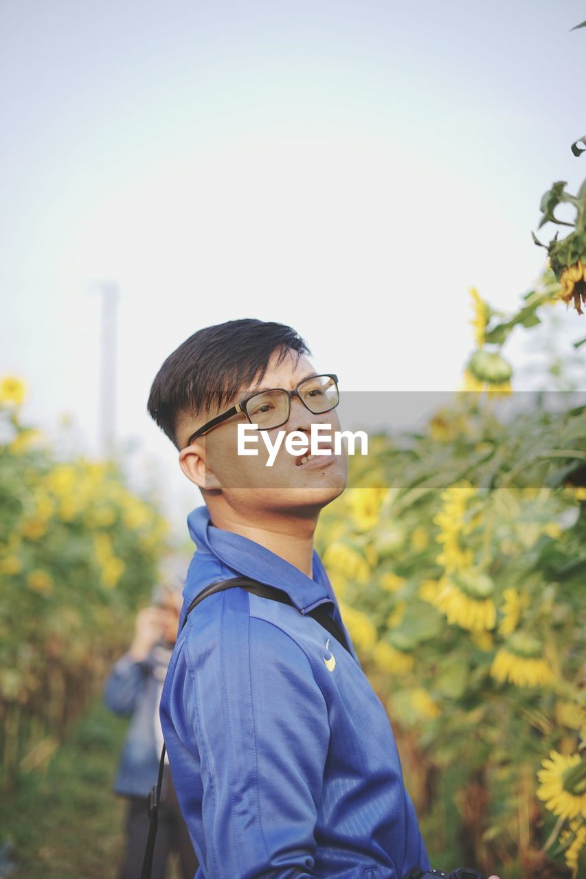 Close-up of man wearing eyeglasses against sky