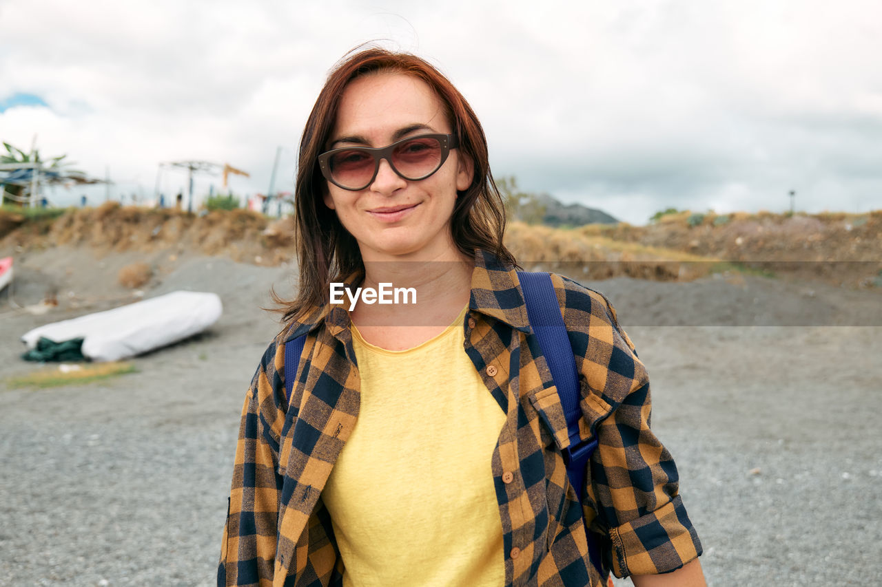 Woman in warm plaid shirt walking by sea on winter beach. traveling. wellbeing and harmony concept.