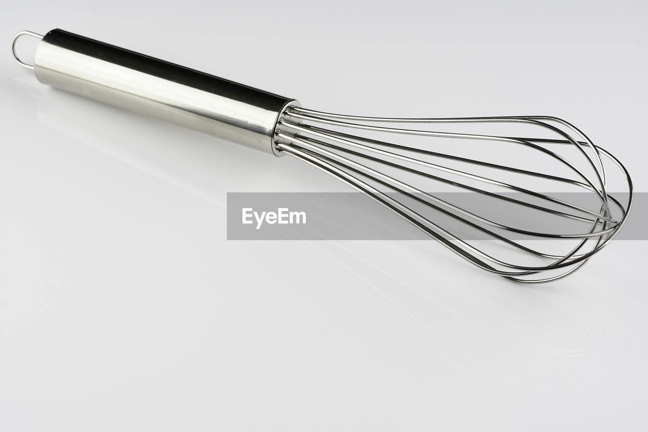 Closeup image of a whisk for bakery over white background