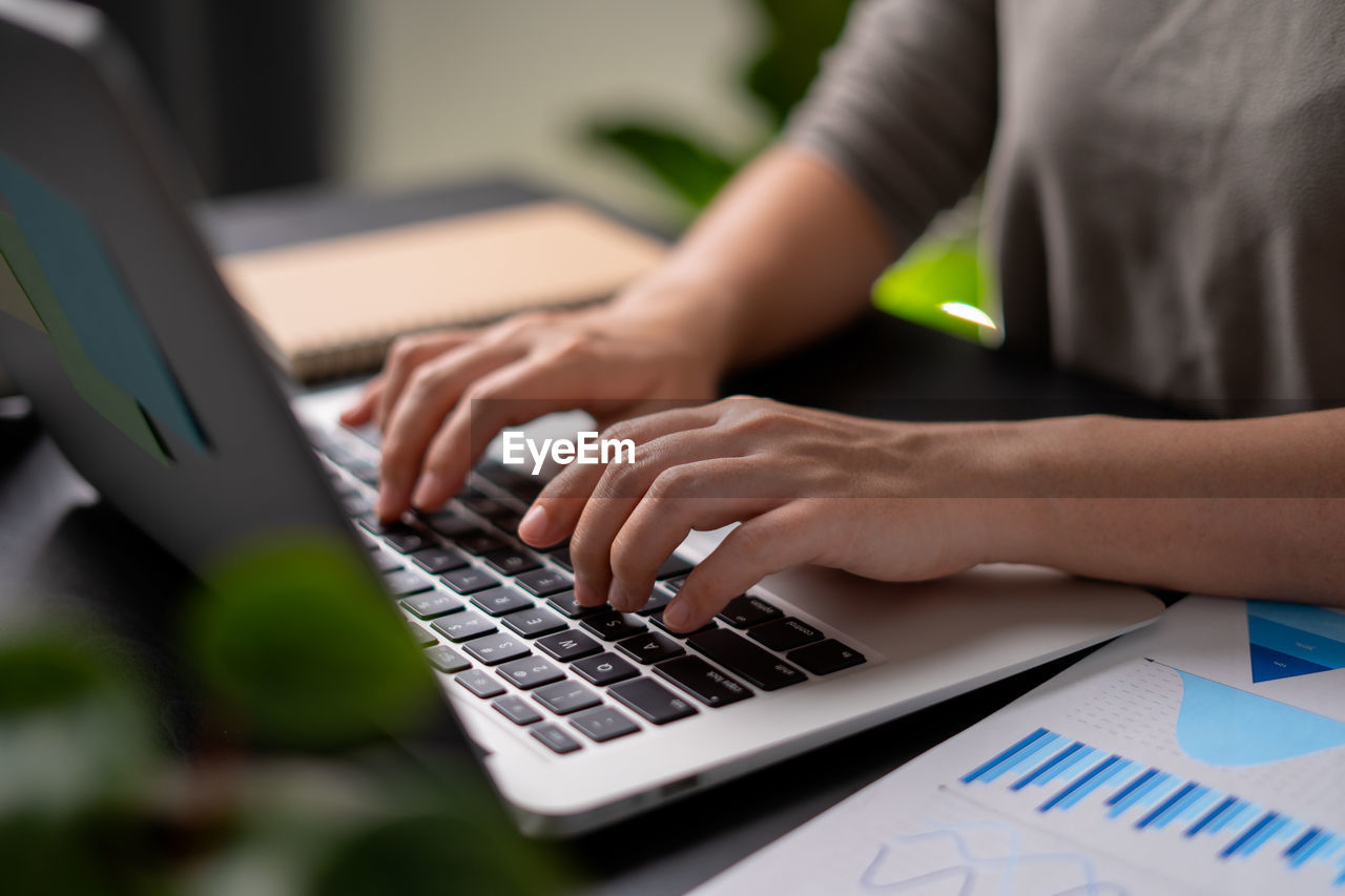 midsection of man using laptop at table