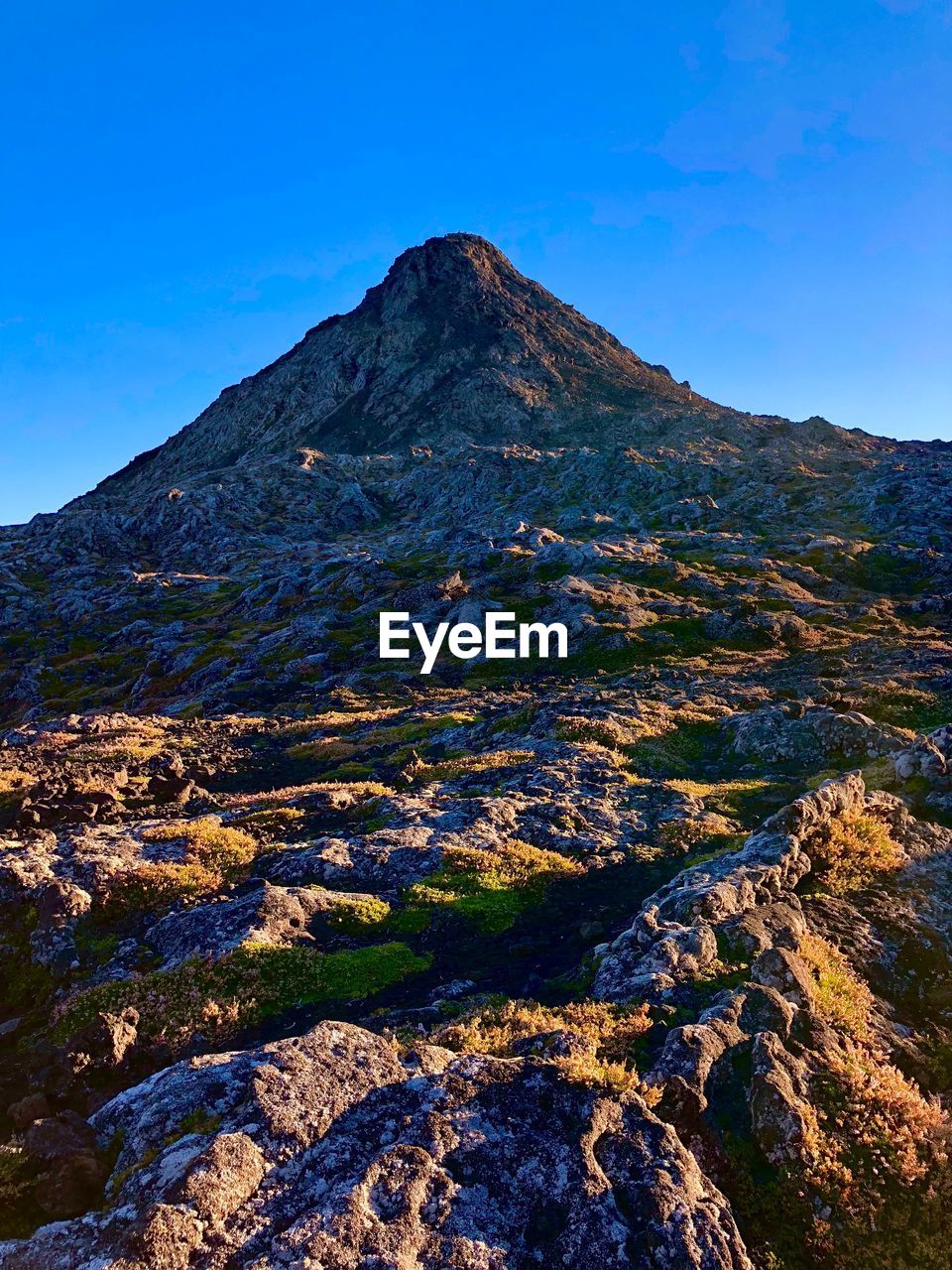 Low angle view of mountain against clear blue sky