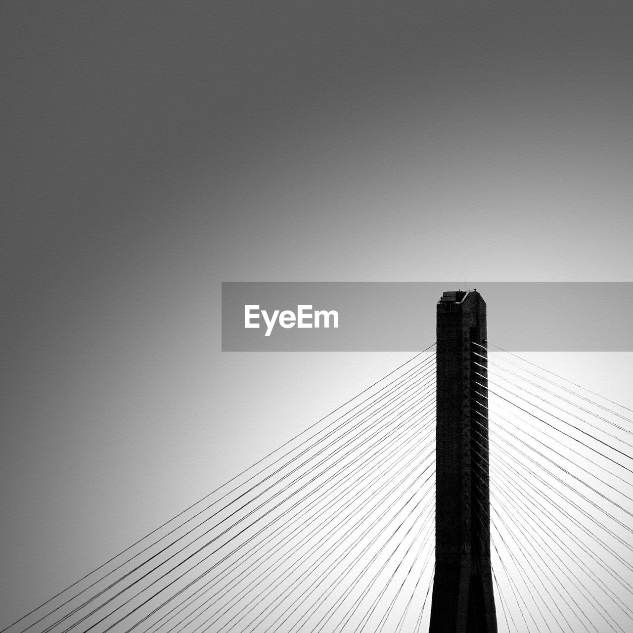 Low angle view of suspension bridge cables against clear sky