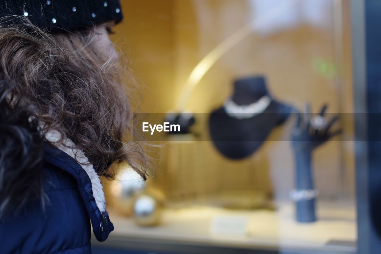 Woman looking at necklace in store