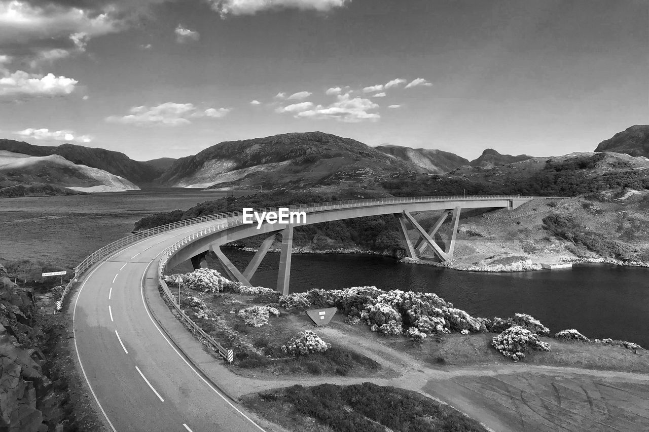 VIEW OF BRIDGE OVER MOUNTAINS AGAINST SKY