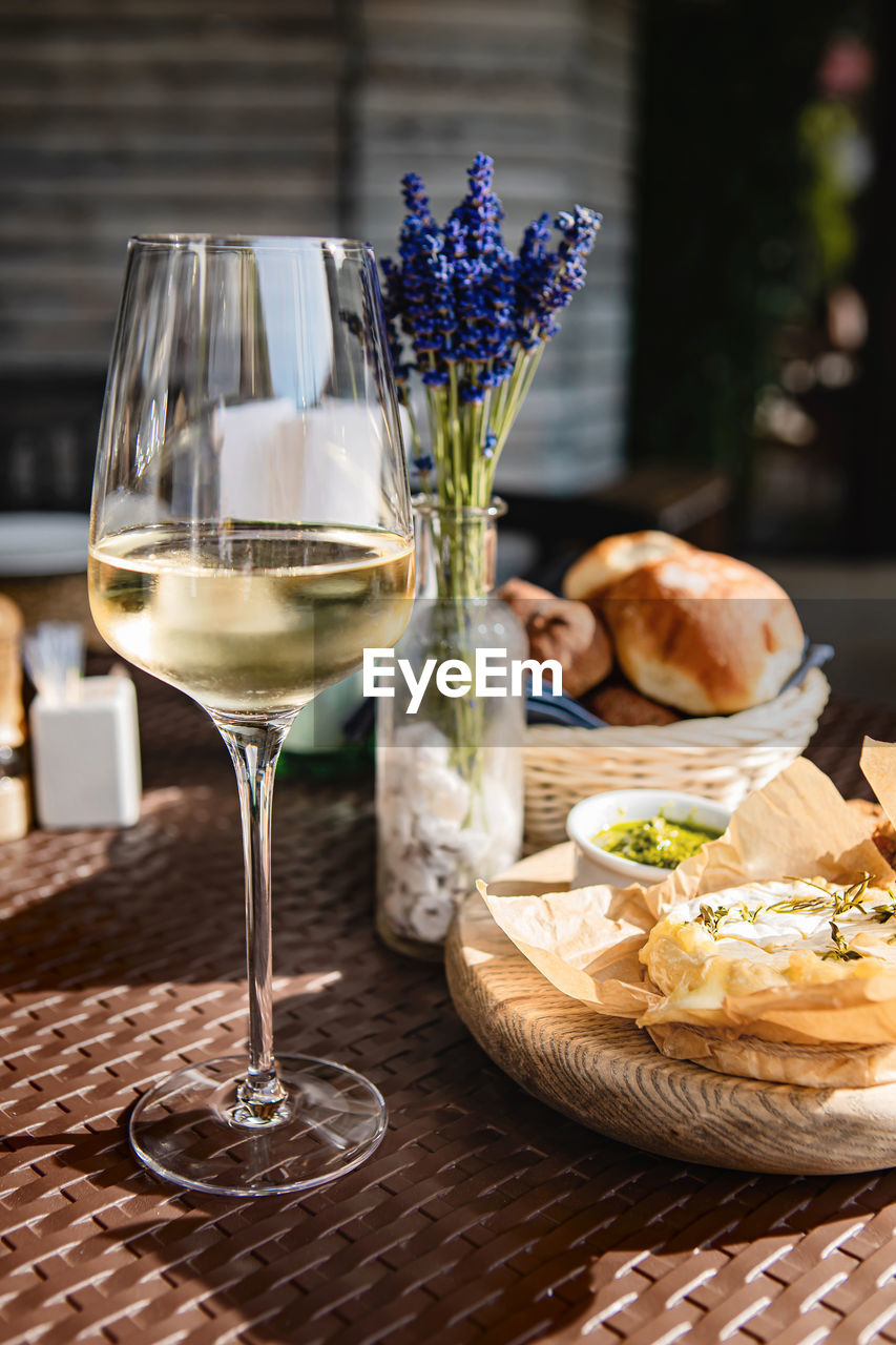 Glass of cold white wine and oven baked camembert cheese