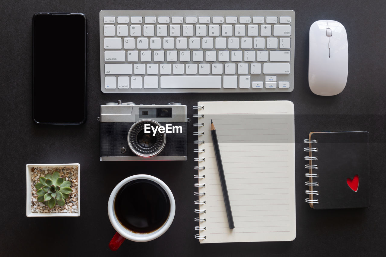 Black desk office or workspace with laptop, smartphone and other work supplies with cup of coffee. 