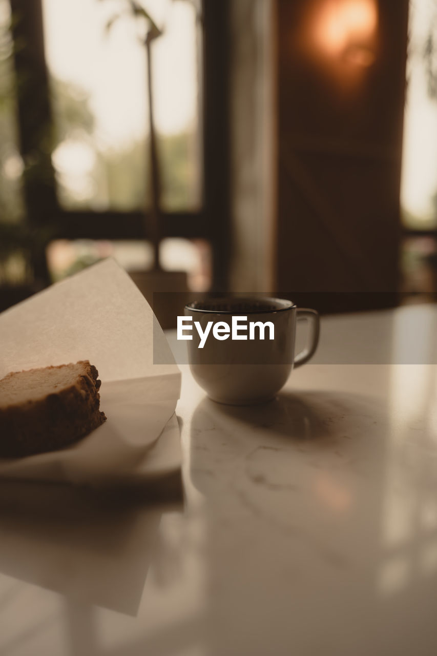 food and drink, table, drink, white, lighting, cup, indoors, tableware, food, mug, selective focus, no people, still life, coffee cup, refreshment, close-up, freshness, coffee, light, morning, focus on foreground, hot drink, black, day, nature, window, tea