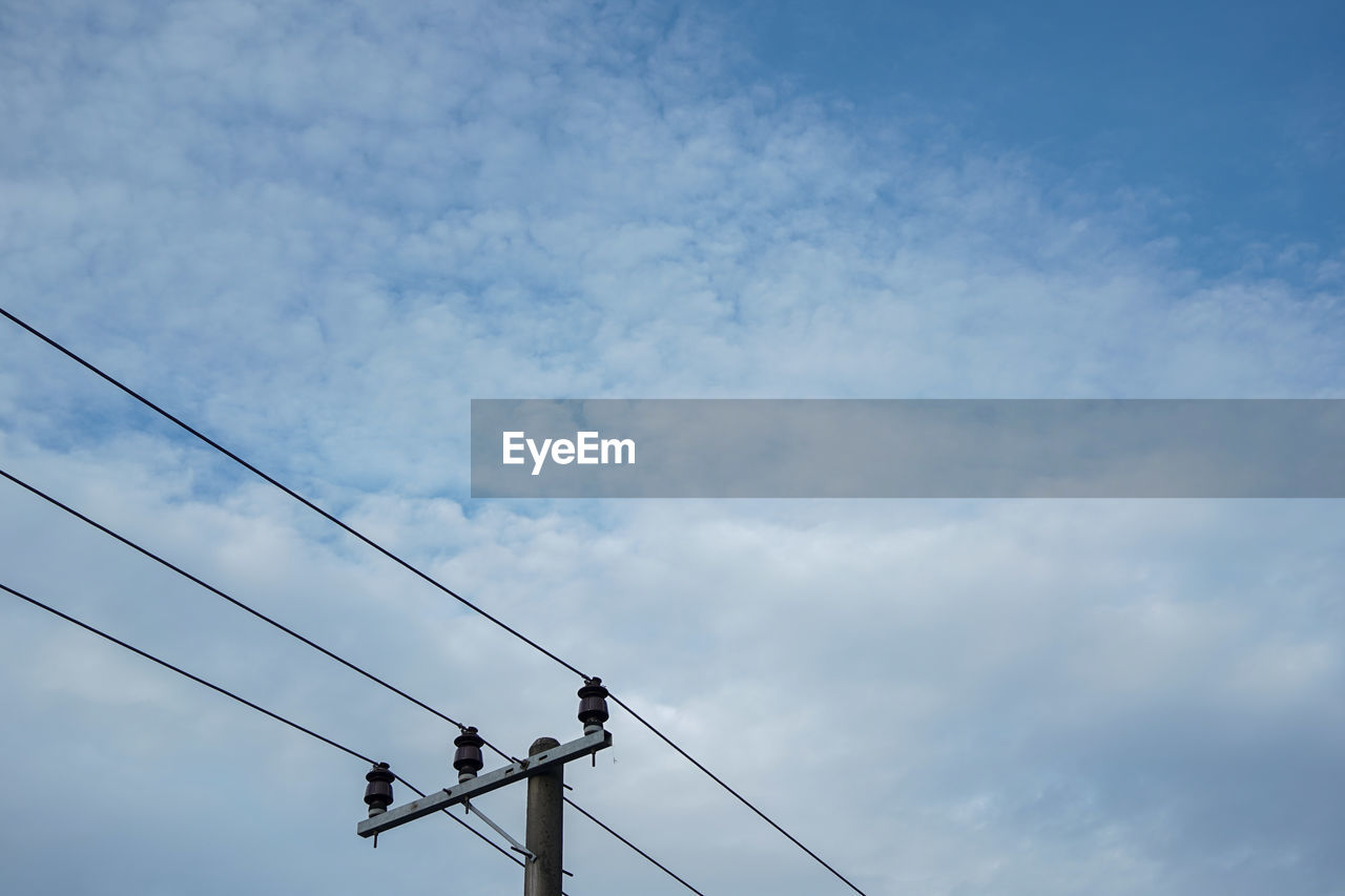 Low angle view of electricity pylon against sky