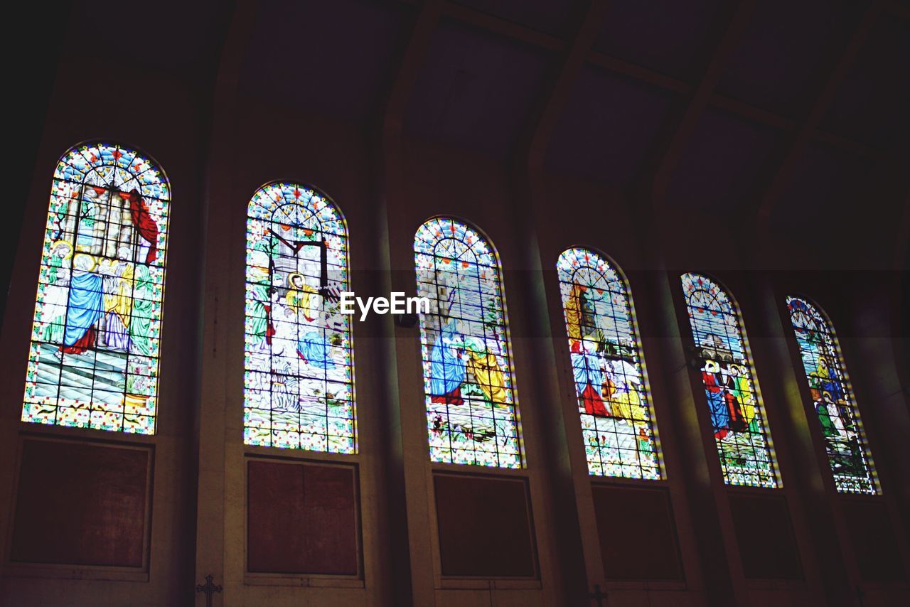 LOW ANGLE VIEW OF MULTI COLORED WINDOW IN CHURCH