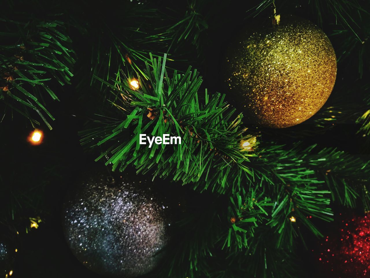 Close-up of golden and silver baubles on christmas tree