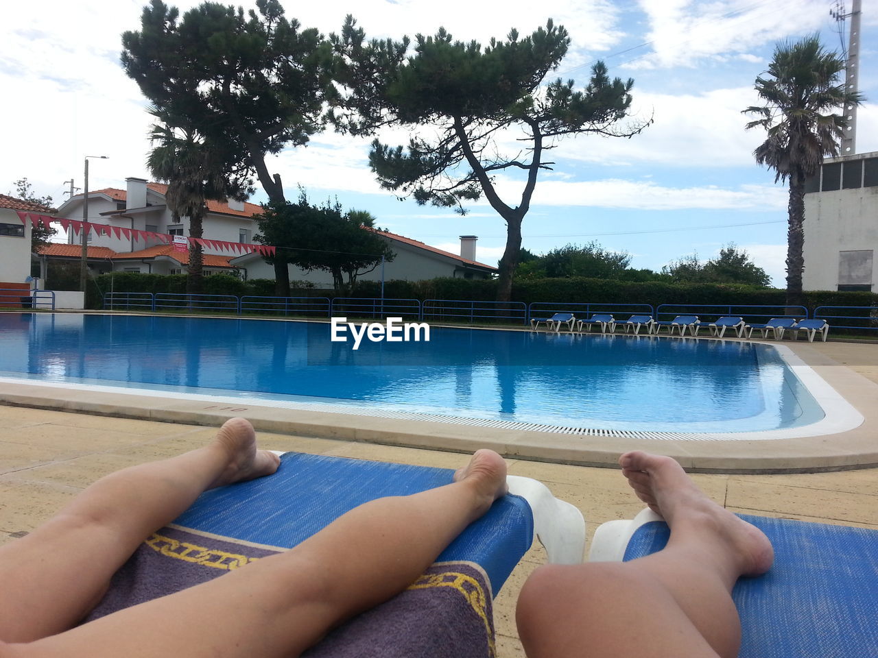 LOW SECTION OF MAN RELAXING IN SWIMMING POOL