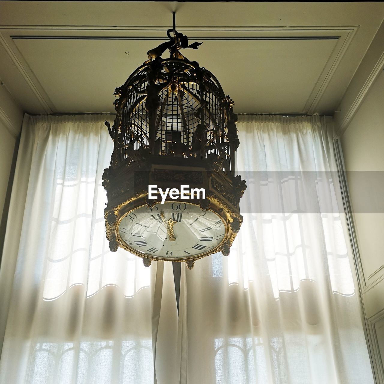 LOW ANGLE VIEW OF CHANDELIER HANGING FROM CEILING OF BUILDING