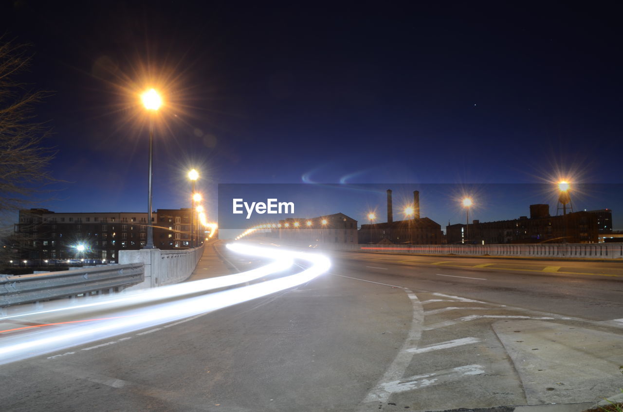 ILLUMINATED LIGHT TRAILS ON ROAD AT NIGHT