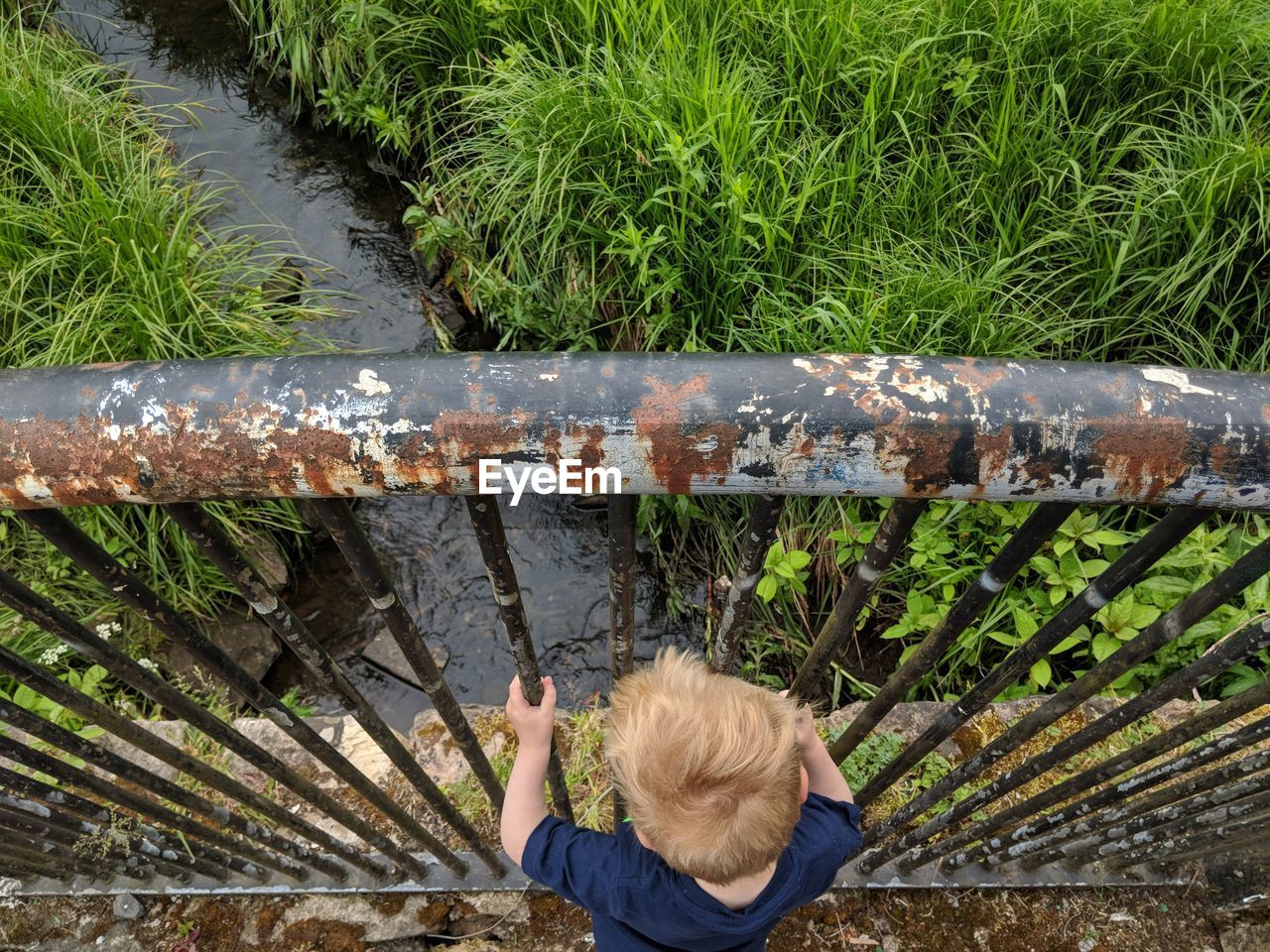 High angle view of boy standing by railing