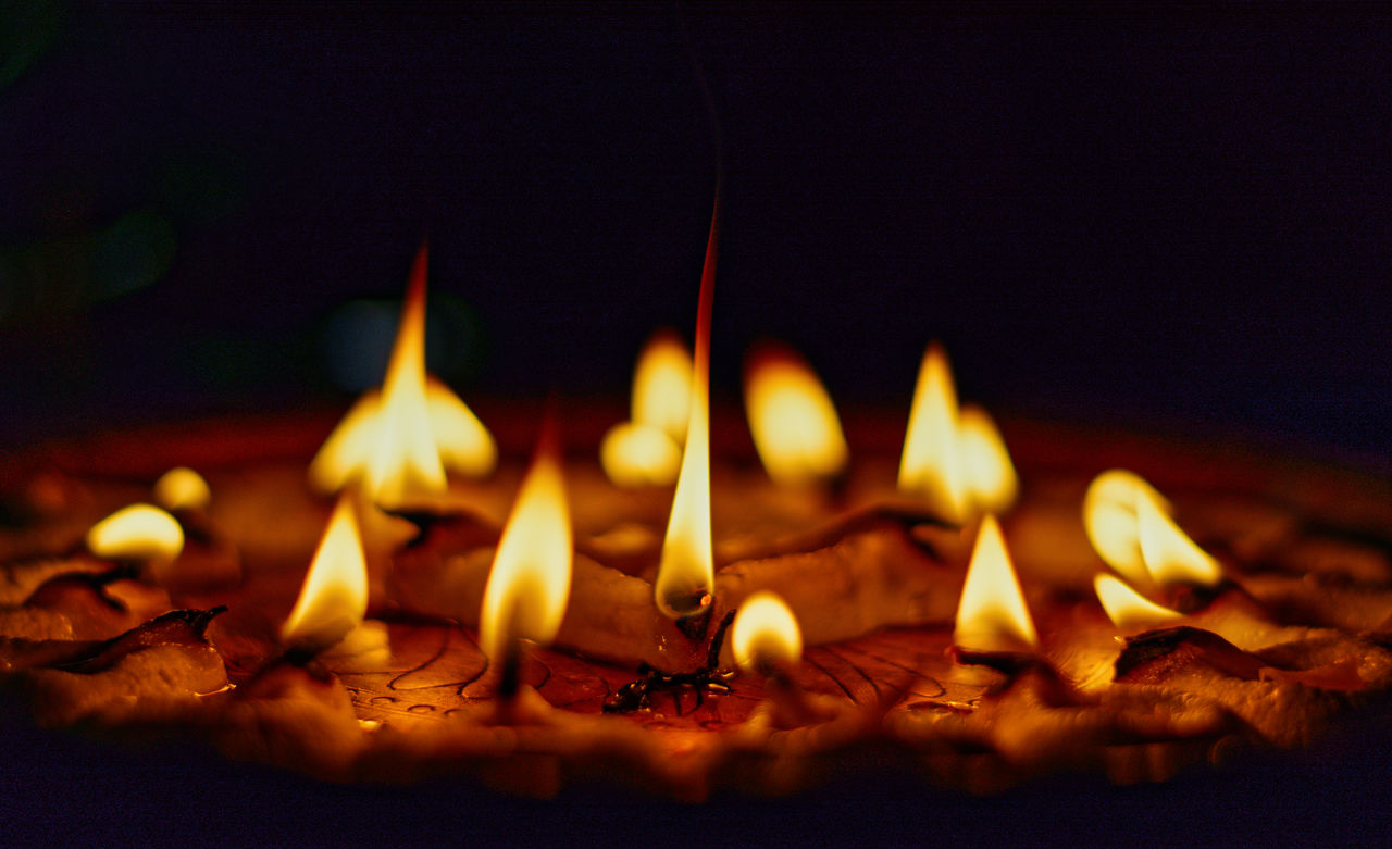 Illuminated diyas during aarti ritual in durga puja in kolkata.