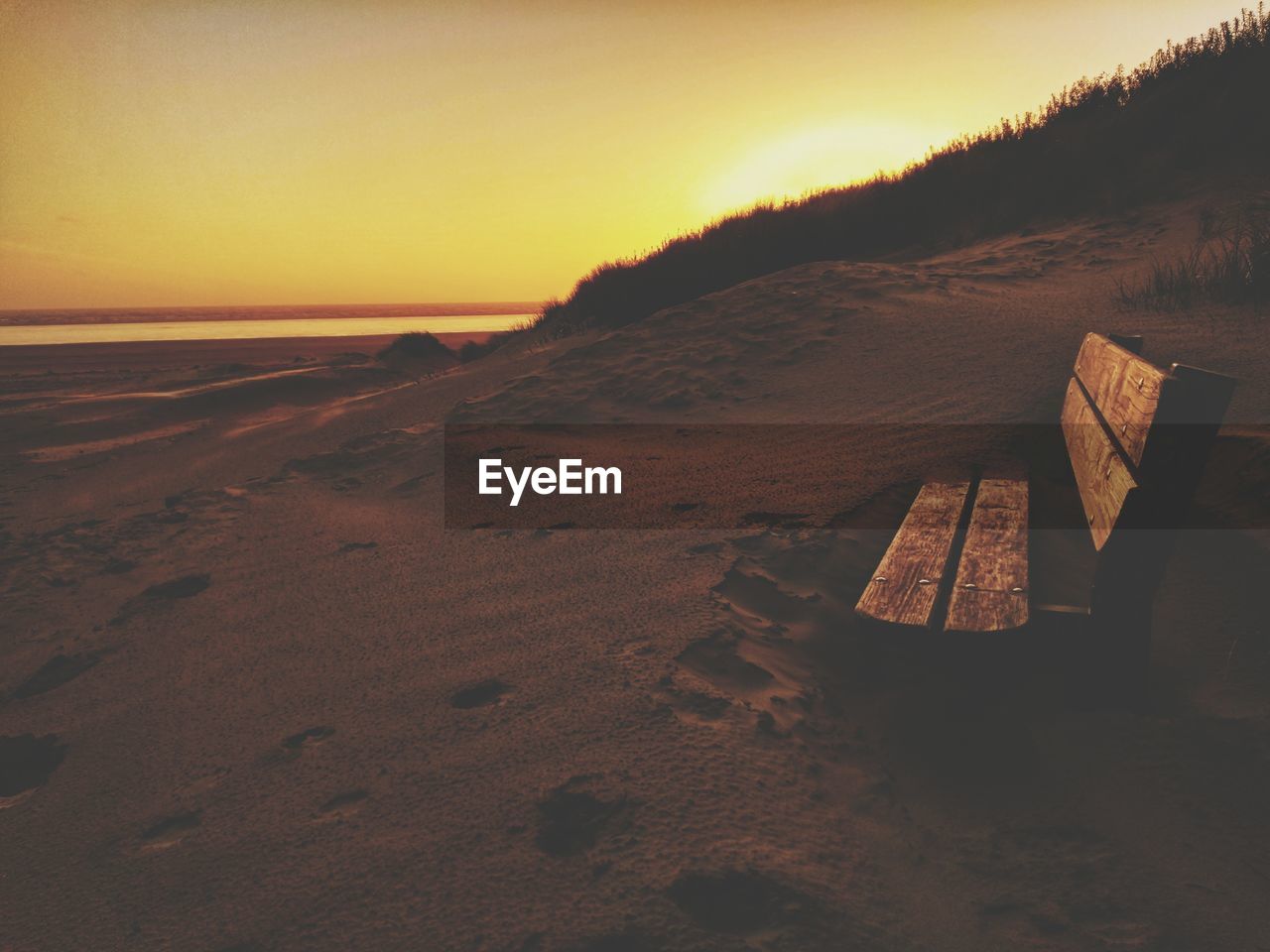 Scenic view of beach against clear sky during sunset