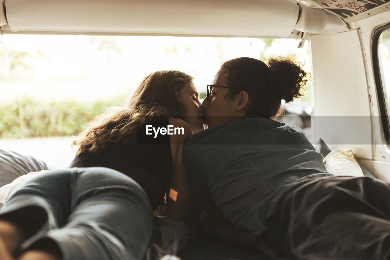 Young couple kissing each other in camping van