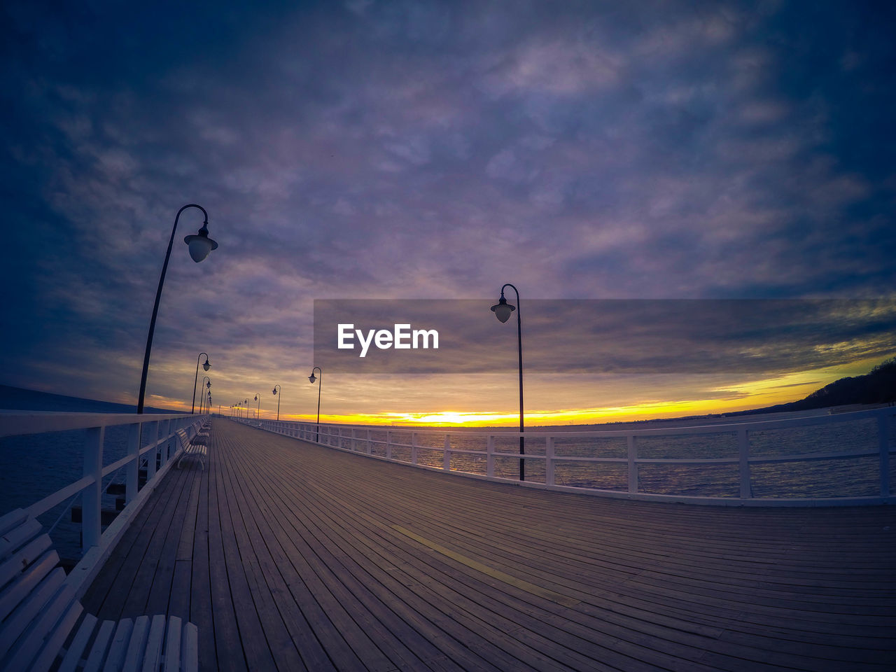 Scenic view of sea against cloudy sky at sunset