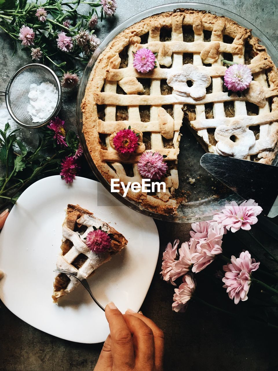 High angle view of pie in plate by flowers on table