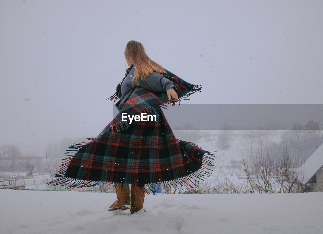 Woman dancing on snow covered land