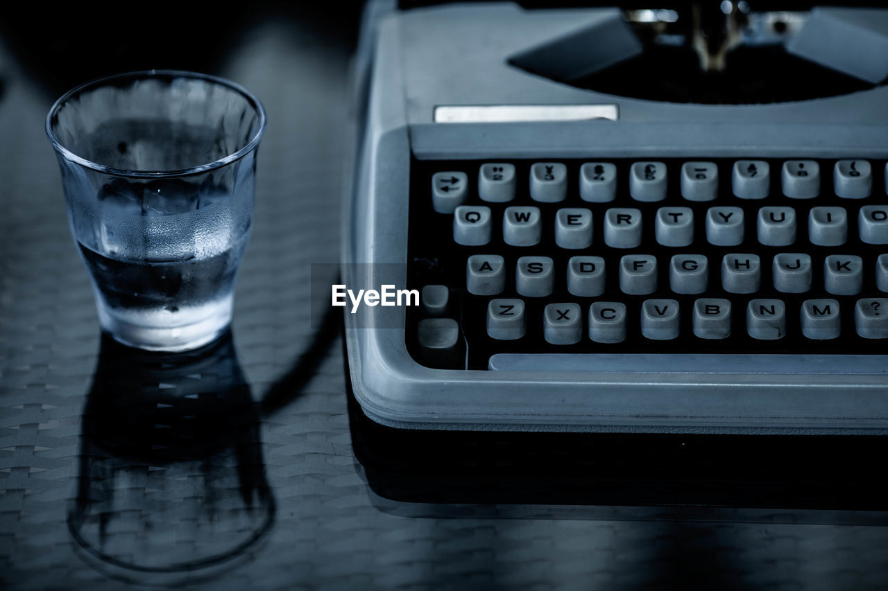 High angle view of drink by typewriter on table