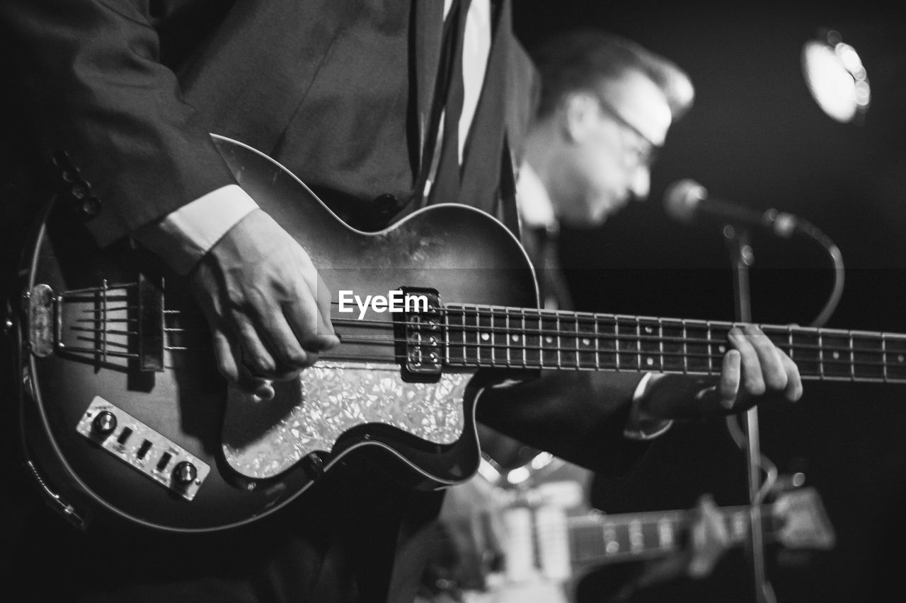 Midsection of man playing guitar