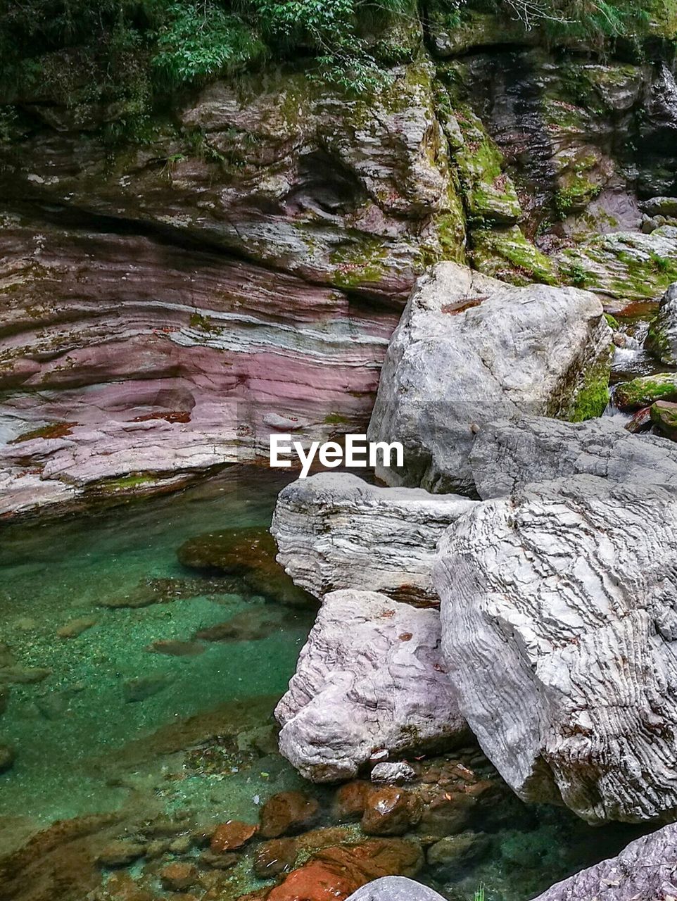 CLOSE-UP OF ROCK FORMATION IN WATER