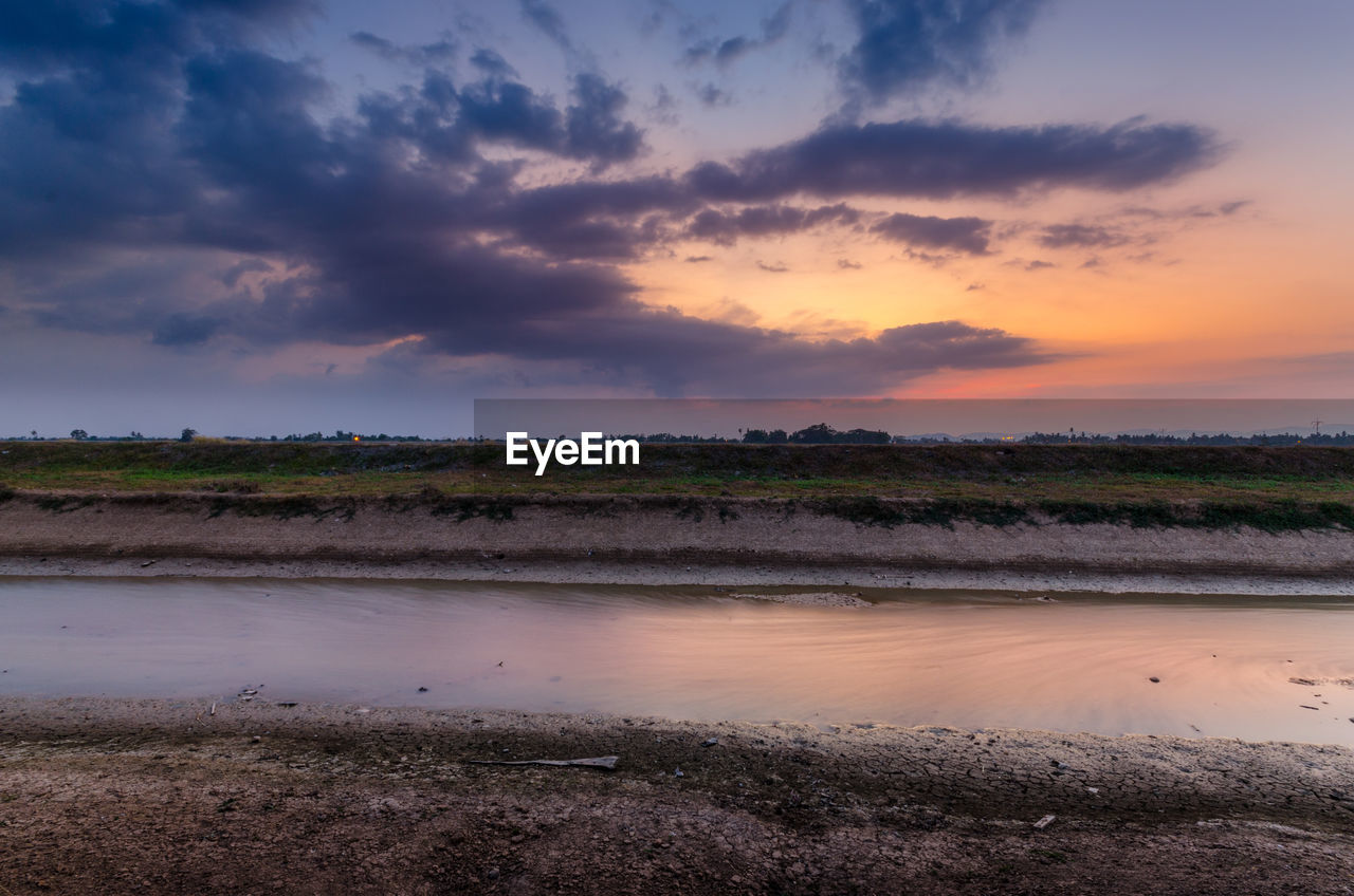 Scenic view of agricultural field against sky during sunset