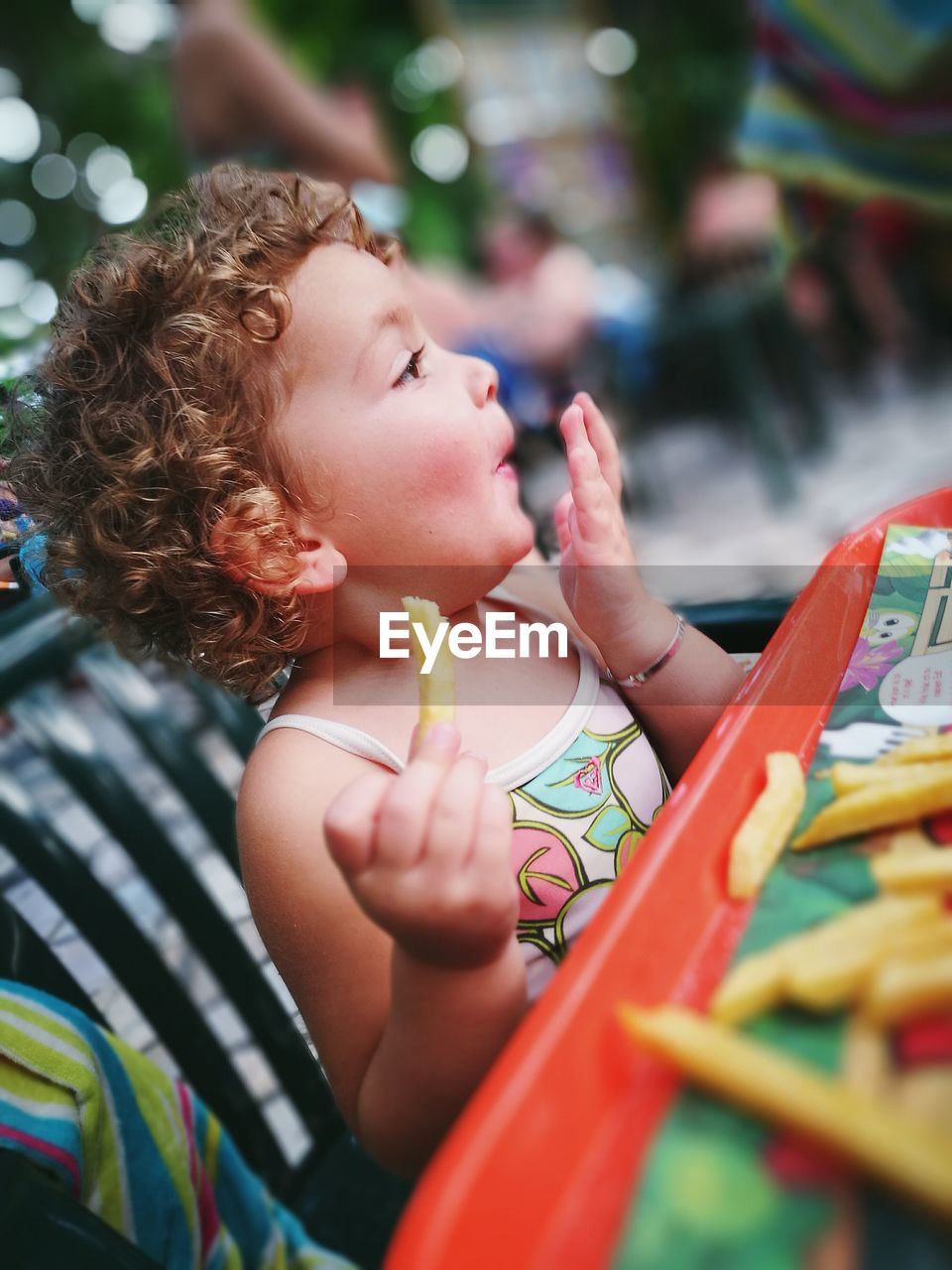 Close-up of boy eating fries at table