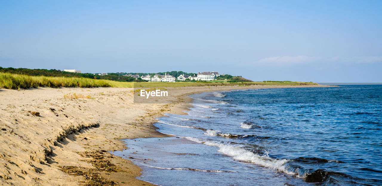 Scenic view of beach against clear blue sky