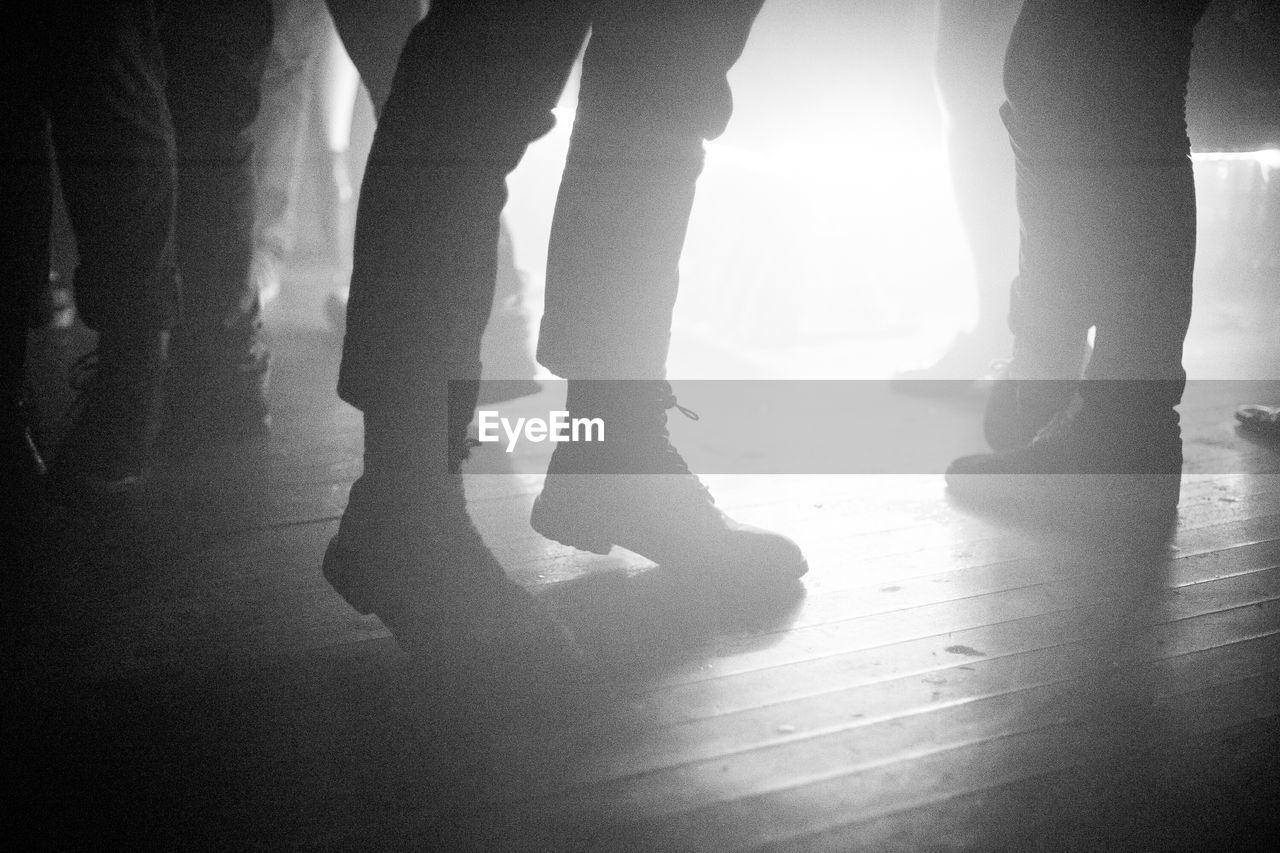 Silhouette people standing on hardwood floor