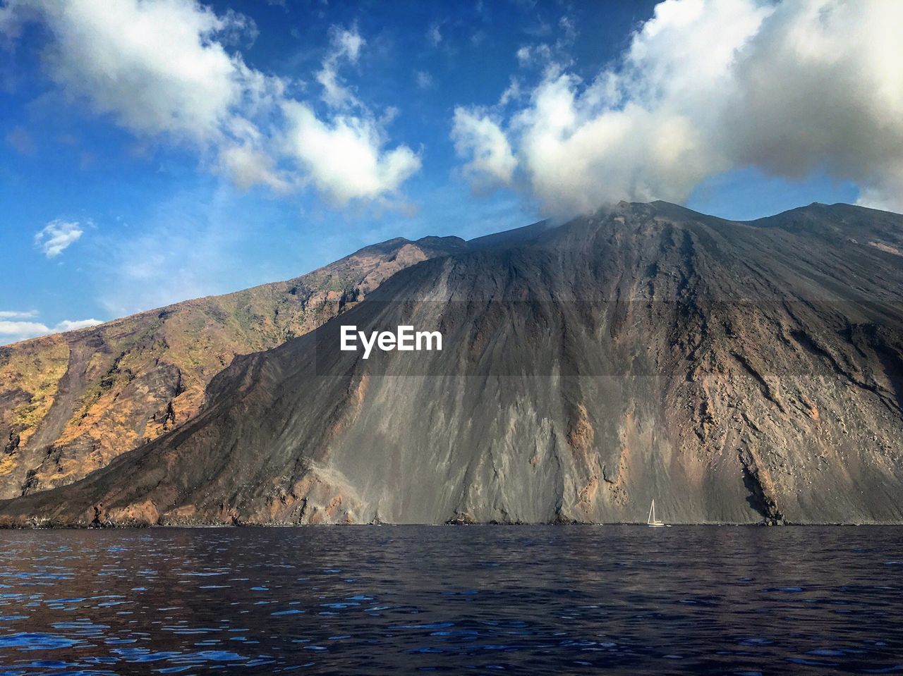 Stromboli volcano by sea against sky