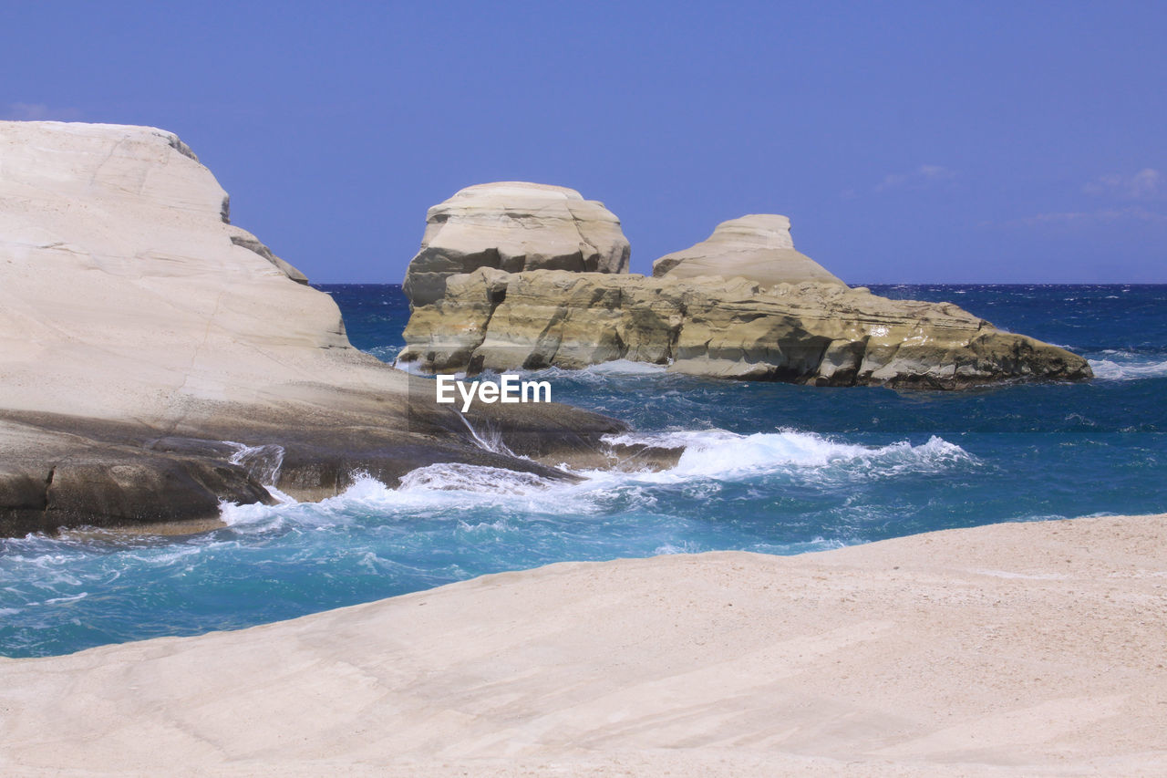 ROCKS ON BEACH AGAINST SKY