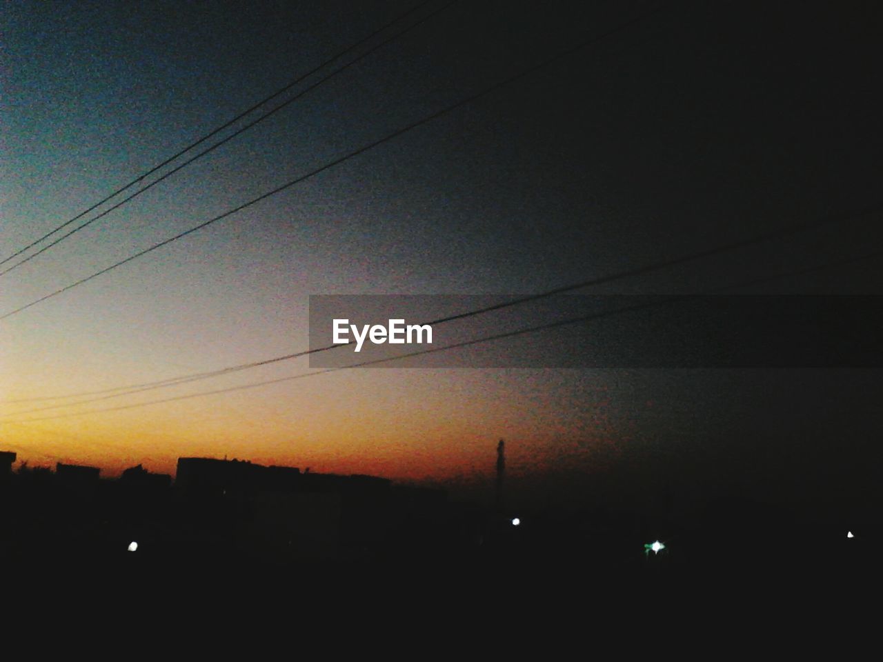 SILHOUETTE OF POWER LINES AT SUNSET