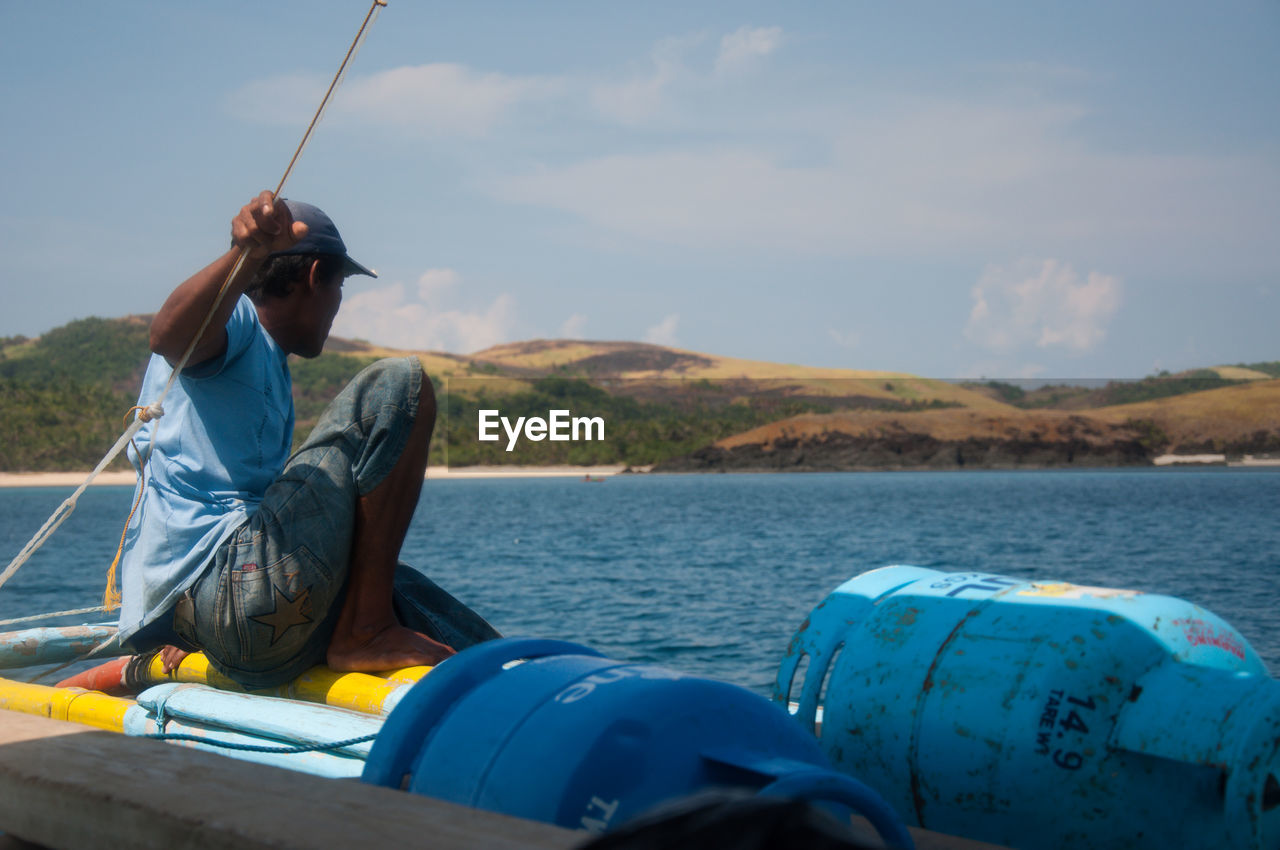 MAN IN BOAT AGAINST SEA