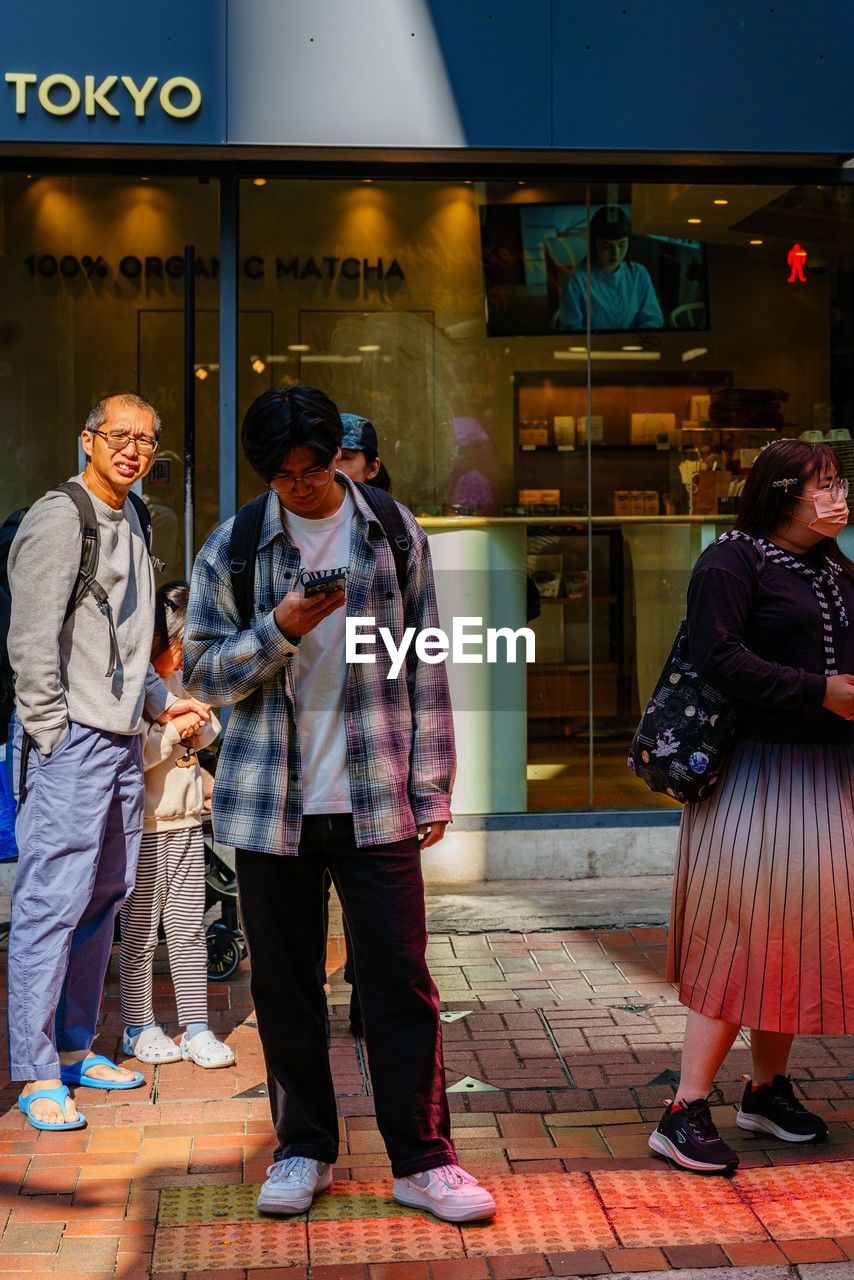 full length, adult, men, street, city, architecture, road, group of people, clothing, standing, togetherness, women, small group of people, communication, building exterior, city life, lifestyles, female