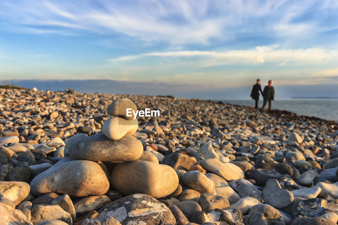 PEBBLES ON BEACH AGAINST SKY