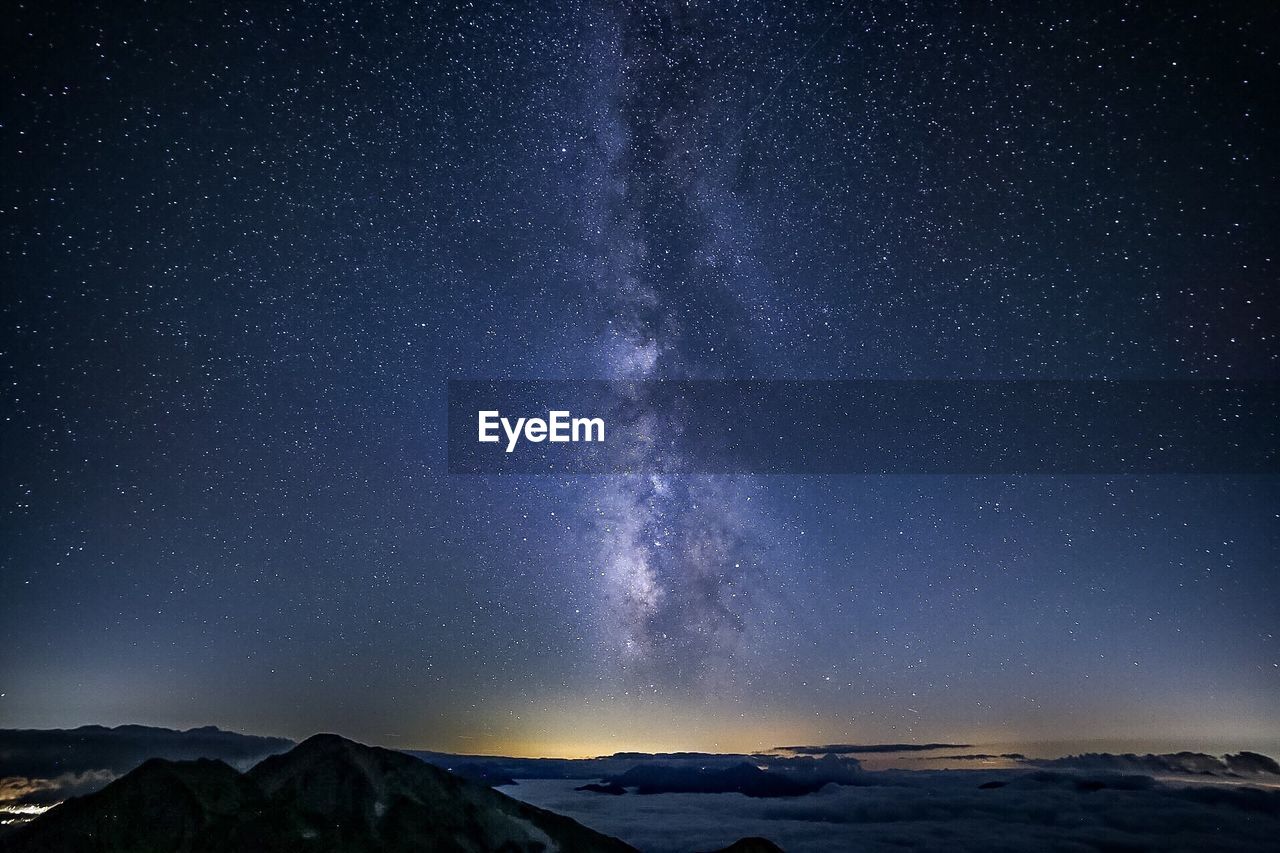 Scenic view of snowcapped mountains against sky at night