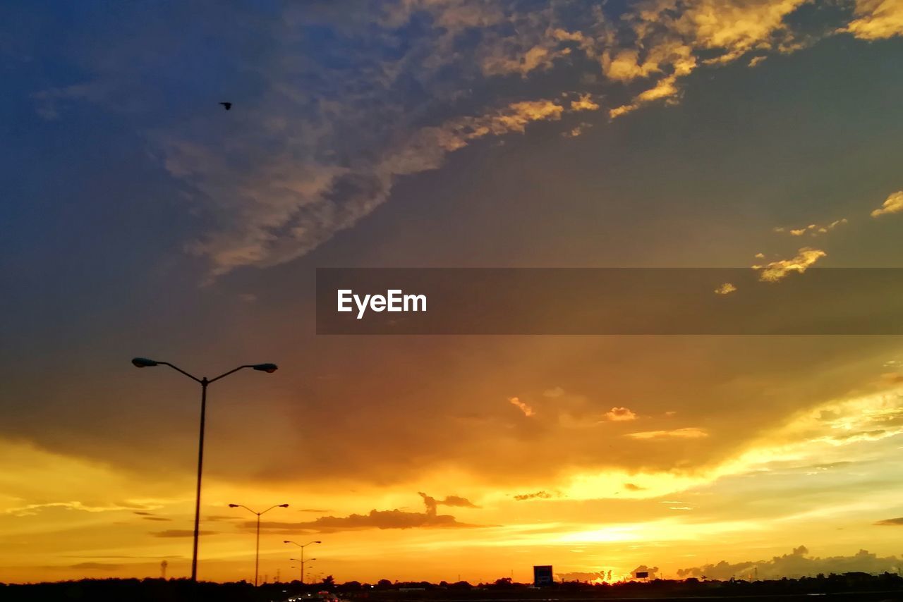 Low angle view of silhouette street against sky during sunset